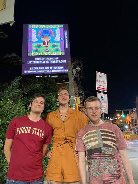 Moth Broth posing with our album release flyer on the LED billboard in Station North. 