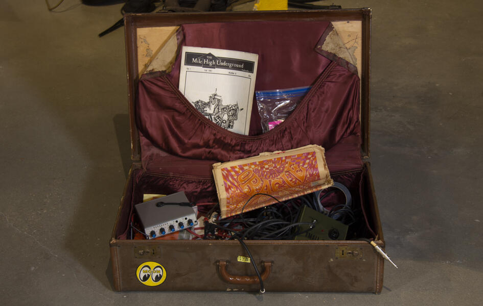 Suitcase with sound equipment and counter culture magazines.
