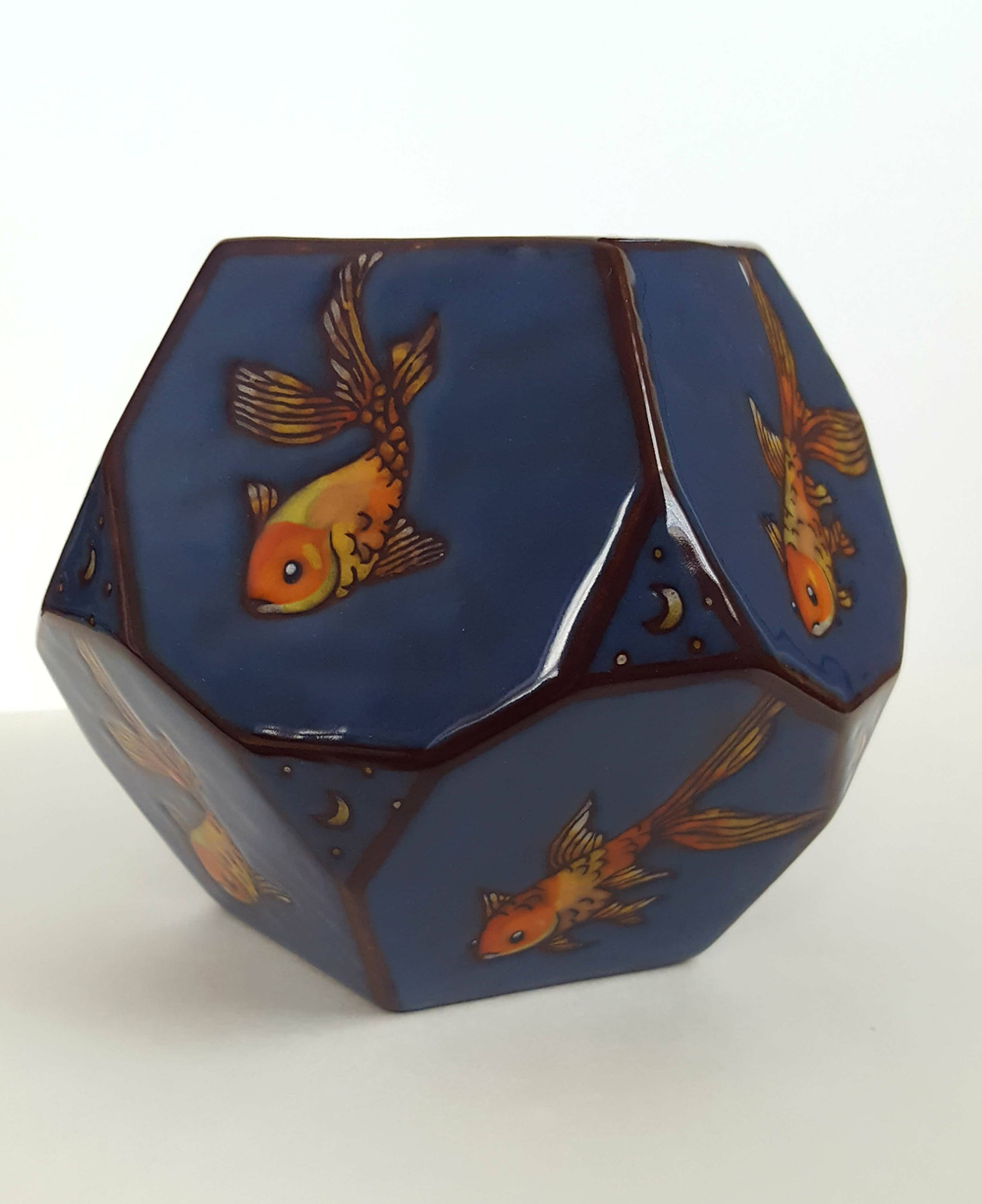 Bowl with painted goldfish on a dark blue background 