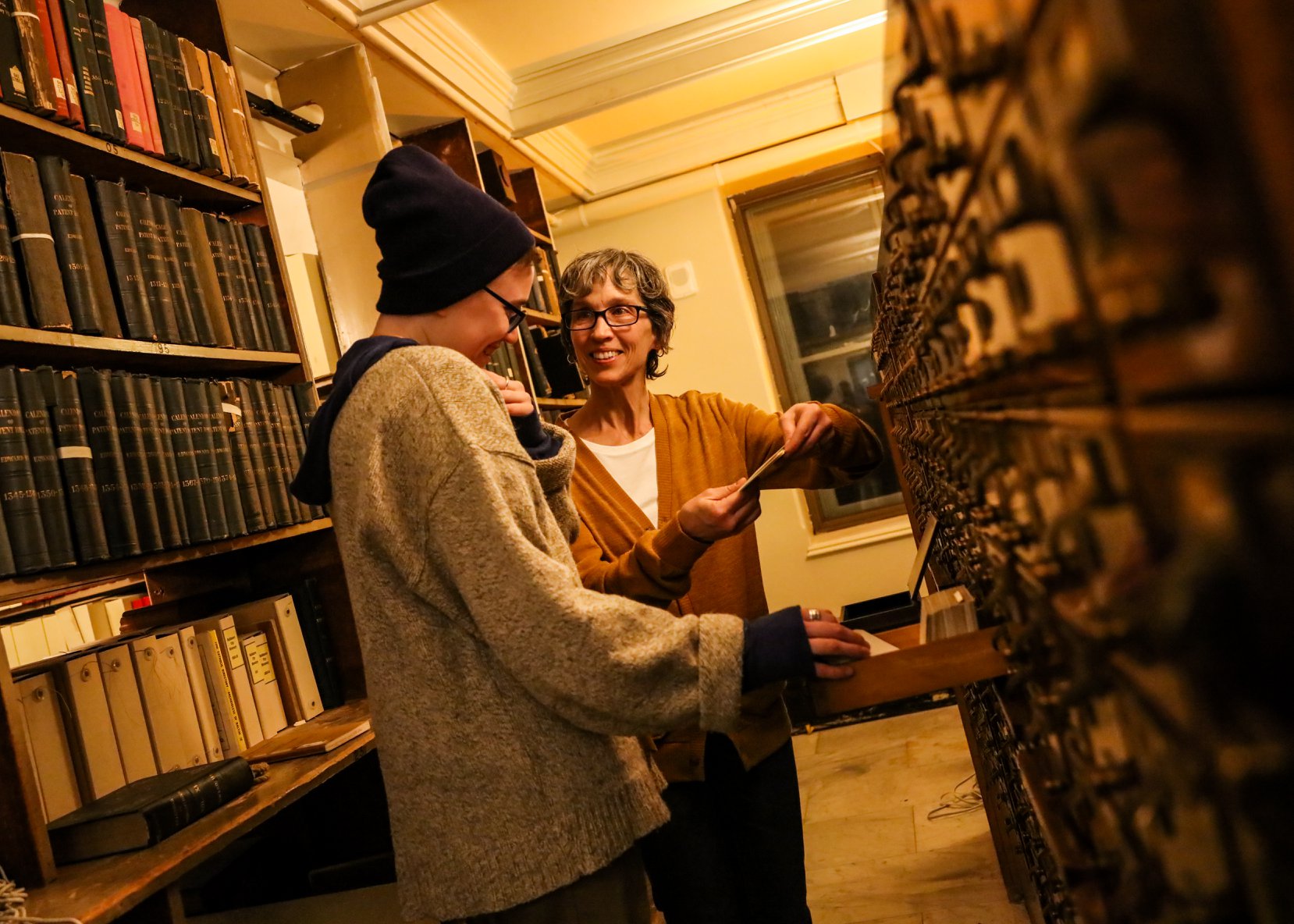 Performer Ursula Marcum interacts with an audience member at the card catalog in "See Also," 2020 