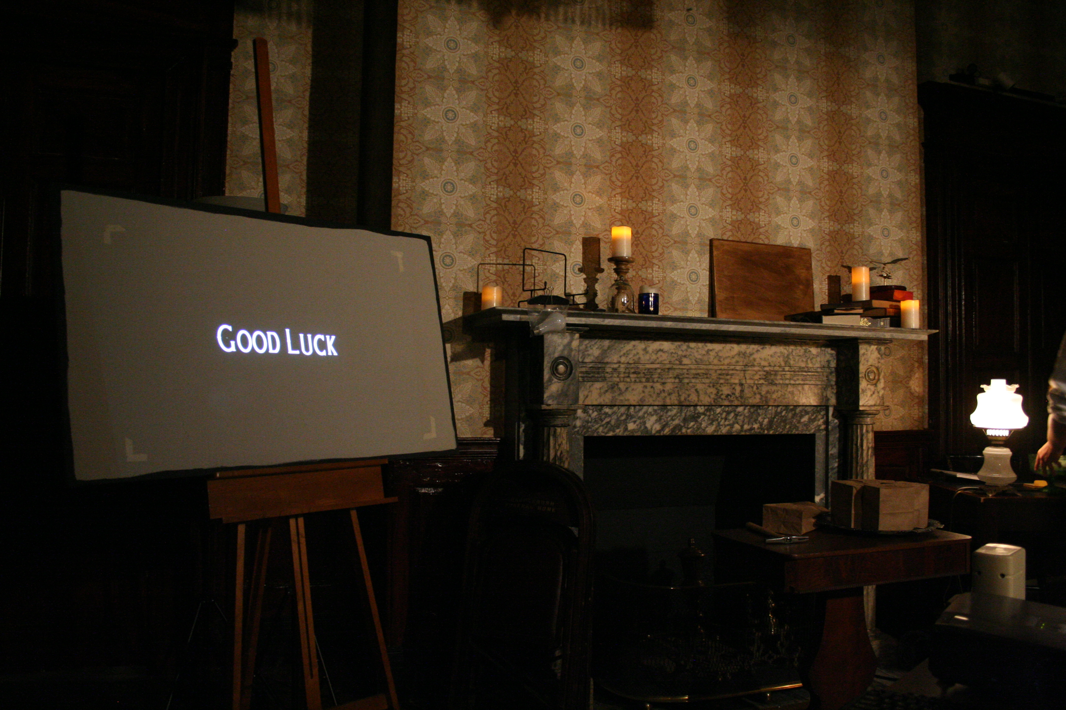 Fireplace with candles, with screen reading "GOOD LUCK"