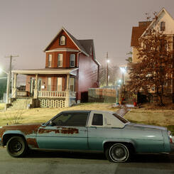 A rusting car in front of homes in Pen Lucy.