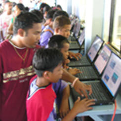 Student teaching the young--the first time many have seen a computer.