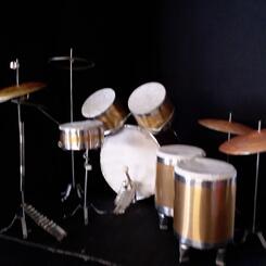 View 2: Miniature drum set for marionette drummer, Reptilian Rockstar, showing rear view with pedals. mixed media 2025