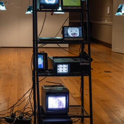 Detail shot of a reclaimed metal shelf used in the installation with the found and salvaged/repaired televisions