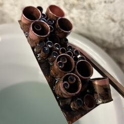 Copper pipe cut-offs representing the many paint buckets used in making a mural