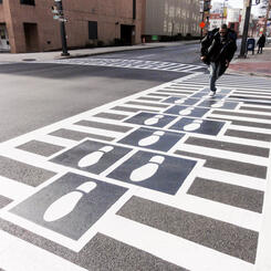 Hopscotch Crosswalk Colossus - business man jumping shoe prints