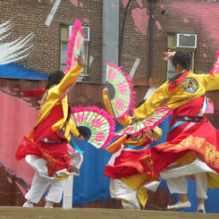 Korean fan dancers with painted wall and shipping container