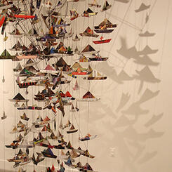 Maelstrom Installation, folded paper boats, tomato tent, and mirror, shown at Towson University in 2014