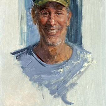 Portrait of a man wearing an Army cap and smiling broadly