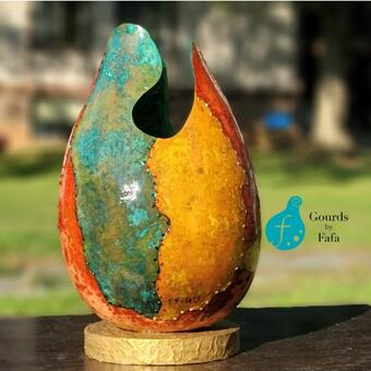 This is a tall gourd vase made in 2023. I used red gold green, colors of the Ghanaian flag and made demarcations  like one would see on a map.