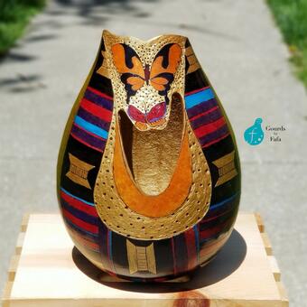 The Butterfly Kente Gourd vase is an original work by Trustina that features the Kente cloth patterns, golden accents and two fancy butterflies.