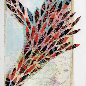 Colorful leaf shapes arranged on a gessoed map from a book