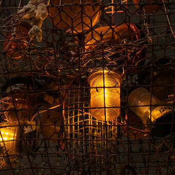 This installation is my response to the Francis Scott Key Bridge accident. At the top is the iconic Maryland crab cage, and shut in the center is the amber strobe light representing the construction crew flashing in random bursts. The whole is crashed to the ground by the heavy masonry.