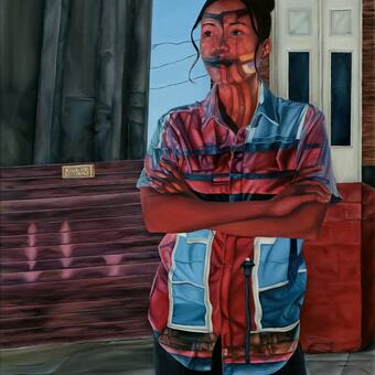 An oil painting of a young woman in a button down shirt. She is standing on a city sidewalk. A Baltimore rowhome is projected over her and her shirt. There are large windows and a streetlight on her shirt. Bricks are outlined in her face and part of the shadow from the building looks like a tiara across her forehead. Behind her is a rowhome, a bright blue clear sky with some telephone lines, a gray concrete building and a purplish wood fence with a POSTED KEEP OUT sign on it. The sidewalk is cracked.