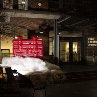 This inflatable installation art uses a Chinese wedding symbol to represent the decline of marriage rates in China. The piece, covered in soapy water and self-sustained by a pump, symbolizes the challenges faced by young people in today's society.