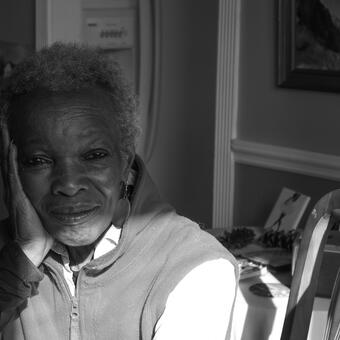 African American woman looking into camera. Image is in black and white