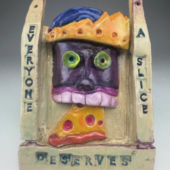 A ceramic sculpture of a person eating pizza. The phrase "Everyone Deserves a Slice" surrounds image.