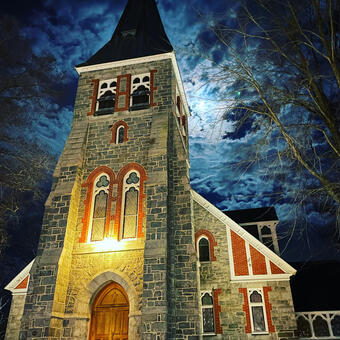 photograph of the front of Christ Church, St. Michael's Parish with the glow of the moonlight behind the steeple