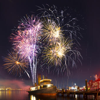 Baltimore Tugboat with fireworks at night