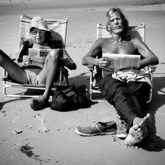 couple on the beach reading, relaxed