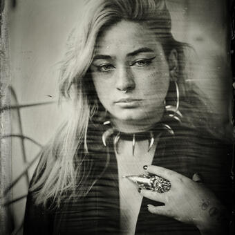 A wet plate collodion photograph of a woman with silver claw ring