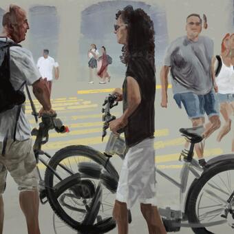 A couple stands holding their bikes as people walk by in the background