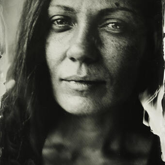 A close up of a woman's face, looking at the viewer; wet plate collodion photograph