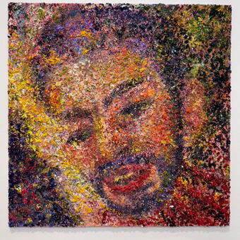A dismembered head fills most of the square panel, its face in 3/4 view, tilting with the top in the upper left corner and the chin in the lower right. A rainbow of color surrounds the head, a dark blue wedge forms in the lower left corner, sliced by a ray of yellow that gently caresses the figures cheek. Red rays spray out from below the chin, as lush green rounds out the upper right corner.