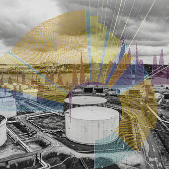 A landscape photograph showing Large oil storage tanks with a brightly painted graph made of dots on top.