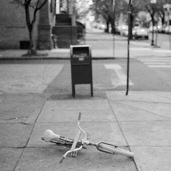 black and white photograph of bicycle on sidewalk