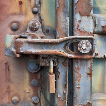 Rusty lock on a rusty handle of a train car door