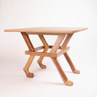 table where the legs are that of an animal with a band of wood constraining them