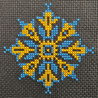 Black background with blue and gold embroidery floss.