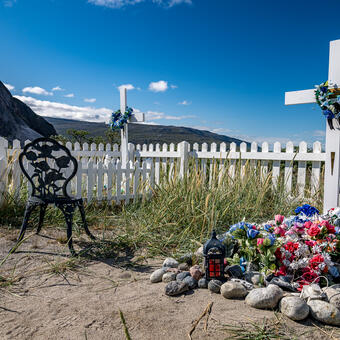 Graves decorated with white crosses and artificial flowers