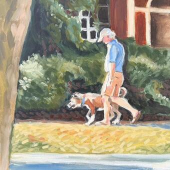 Man walking his dog bathed in sunlight in front of lush green bushes and a red brick home.
