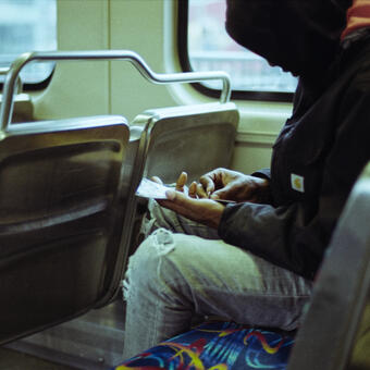 A person plays a scratch off ticket while seated on a train