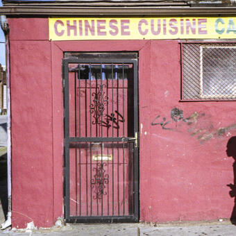 shadow of a boy on a red Chinese takeout wall