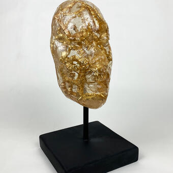 Resin face cast with bamboo earrings embedded inside.