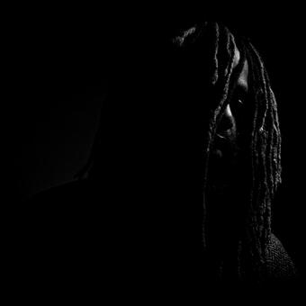 black and white portrait of Black man locs over face, lost
