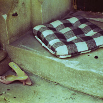 A 35mm film photograph of a pillow and pair of high heeled shoes resting on the steps of a Mount Vernon cathedral. 