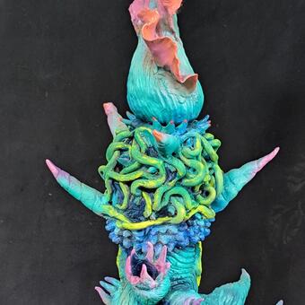 Statuesque surreal clay sculpture about 4 ft , painted in greens ,blues and pinks, looks like sea life