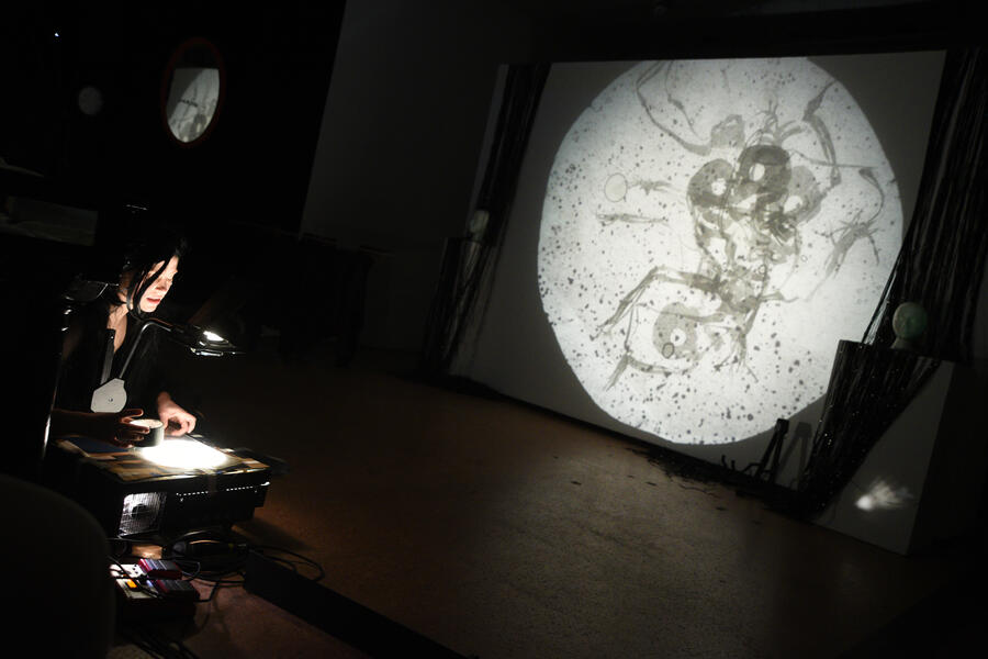 Red used an overhead projector to project silhouettes of skeletons embracing in a dappled background.
