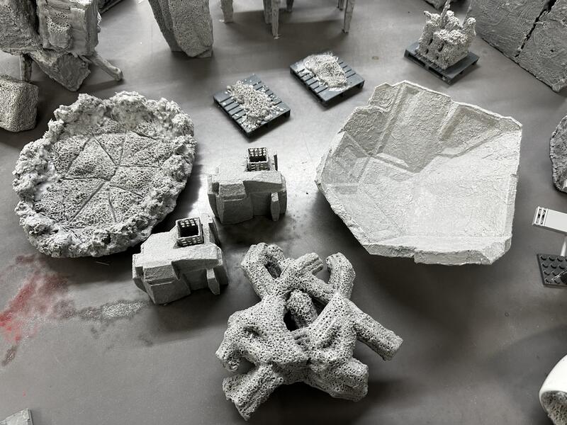 Various grey objects on table with strange textures, some look like prototypes for an undersea sculpture garden