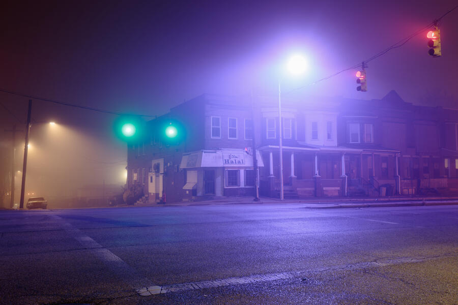 Cars pass through a foggy intersection in Park Heights.