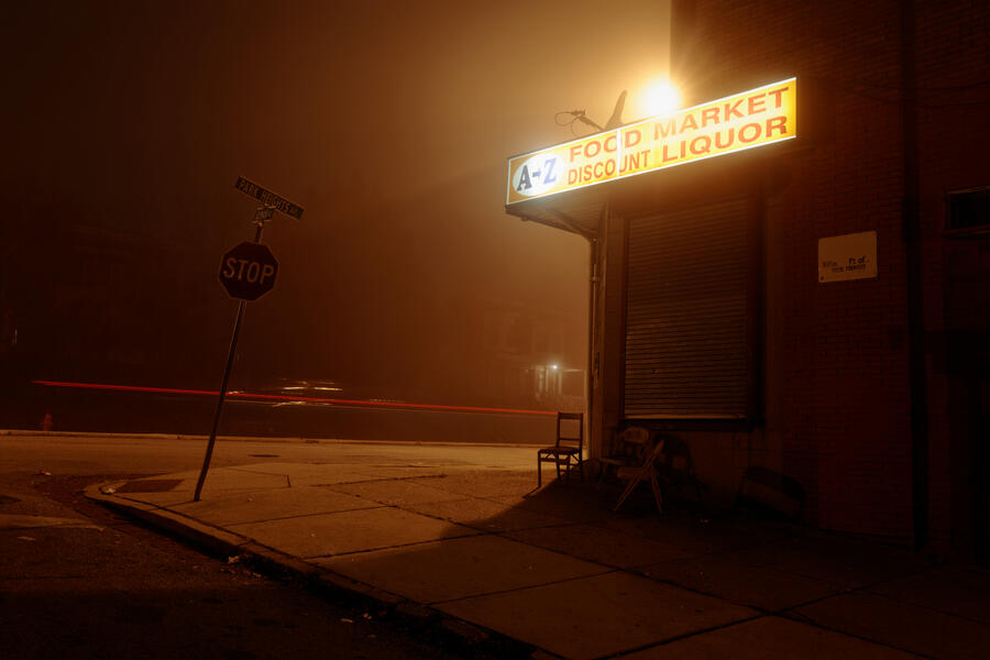 The light from a Park Heights liquor store sign illimunates the fog.