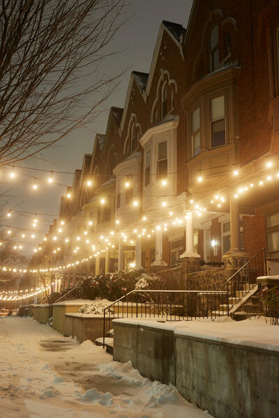 Snowy rowhomes with string lights on Linden Ave