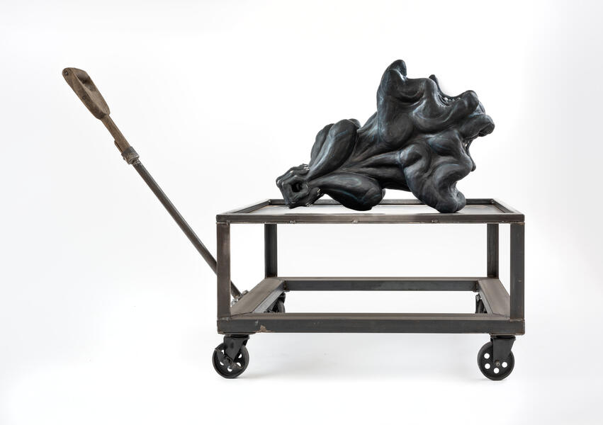 A figure with two heads on a metal cart