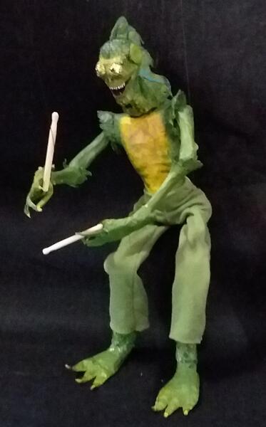 Reptilian Rockstar, a mixed media marionette designed to play drums