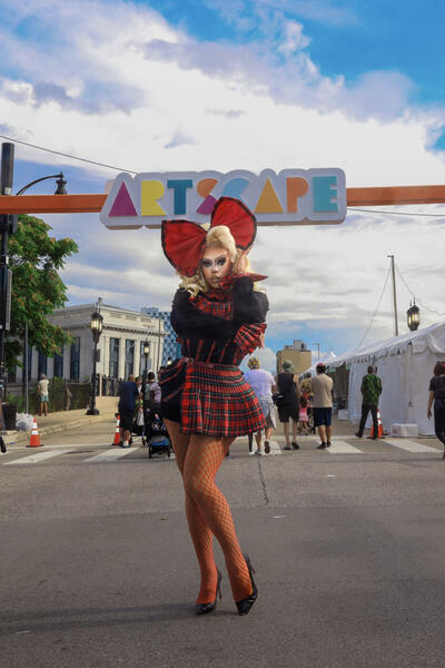 Reclaiming the StageIn this image, I stand confidently in the Plaid Rebirth ensemble beneath the iconic Artscape arched logo. Festival-goers walk around me, enjoying Baltimore’s vibrant celebration of creativity and community. The dynamic energy of the fe